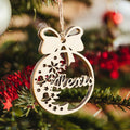 Personalized wooden Christmas ornament with name 'Alexis', adorned with a bow and festive design, hanging on a tree.